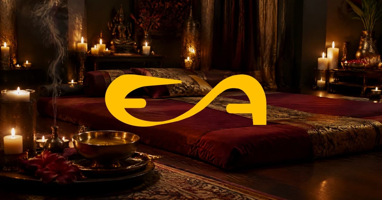 Sala de massagem tântrica com almofadas bordô, velas e óleo morno